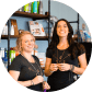 Suzie Mills & Julia Lopez, Co-owners of Honest Soul Yoga smiling in front of a shop front